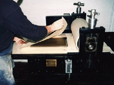 PLACING THE PAPER ON THE PLATE - The photogravure process is one in which ink from the plate is forced from the grooves onto the paper by the pressure of the press.